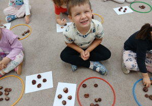 05. Chłopiec ułożył wzór z kasztanów.