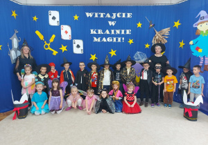 Przedszkolaki wraz z paniami w pięknych strojach pozują do zdjęcia.