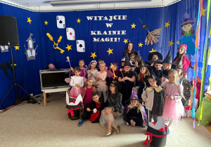 Przedszkolaki wraz z paniami w pięknych strojach pozują do zdjęcia.
