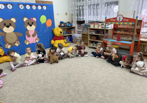 Przedszkolaki przytulają się do misiów.