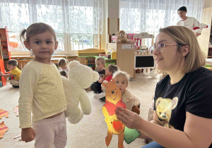 Dziewczynka sprawdza co miś ma w brzuszku.