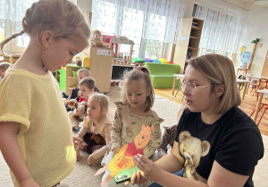 Dziewczynka sprawdza co miś ma w brzuszku.