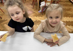 Dziewczynki jedzą wafelki z miodem.