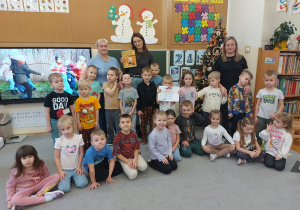 Pamiątkowe zdjęcie grupowe z czytającym rodzicem.