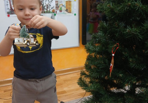 03. Chłopiec trzyma autko na choinkę.