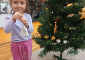 05. Dziewczynka trzyma ozdobę choinkę.
