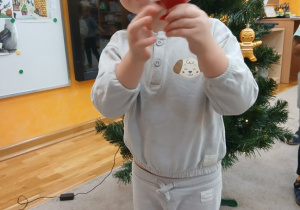 07. Chłopiec trzyma ozdobę na choinkę- Mikołaja.