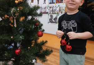 11. Chłopiec z czerwonymi bombkami.