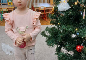 12. Dziewczynka z czerwoną bombką.