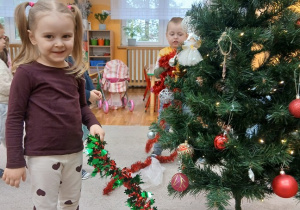 17. Dziewczynka trzyma łańcuch na choinkę.