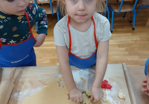 07. Dziewczynka wykrawa ciasteczko w kształcie pierniczka.