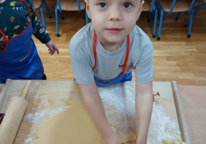 10. Chłopiec wykrawa ciasteczko w kształcie pierniczka.