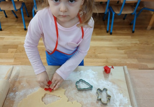 12. Dziewczynka wykrawa ciasteczko w kształcie gwiazdki.