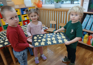 21. Dzieci trzymają blaszkę z ciasteczkami.