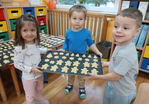 22. Dzieci trzymają blaszkę z ciasteczkami.