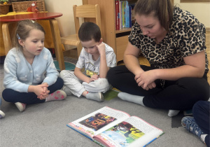 Dzieci siedzą słuchają bajki.