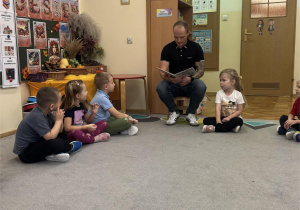 Tata dziewczynki z grupy Promyczki czyta bajkę.