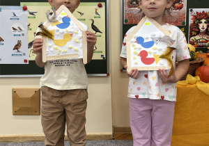 Chłopiec i dziewczynka przedstawiają swoje karmniki.