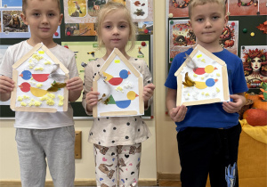 Dzieci pokazują swoje gotowe prace - karmniki z ptakami.