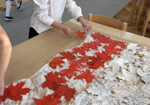 Dziewczynka układa czerwony pas.