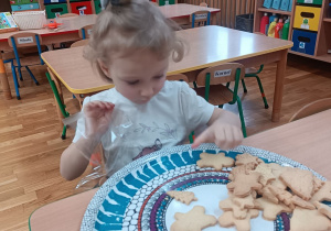 Dziewczynka pakuje wypieki do woreczka.