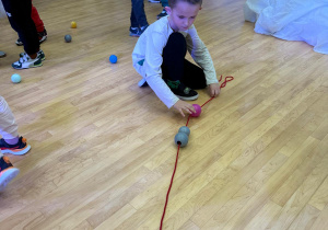 Chłopiec tworzy łańcuch z piłeczek.