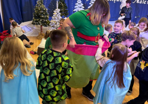 Dzieci wrzucają piłeczki do elfa spodni.