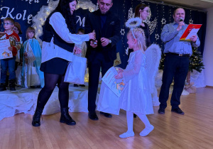 Dziewczynka odbiera nagrodę za zajęcie III miejsca.