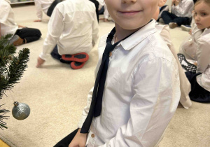 Uśmiechnięty chłopiec przy choince.