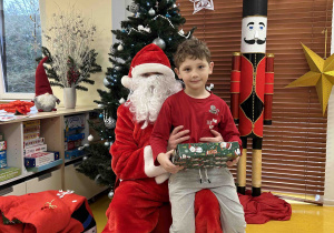 Chłopiec trzyma prezent od Mikołaja.