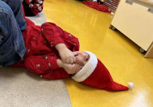 Chłopiec pozuje do zdjęcie w czapce mikołaja.