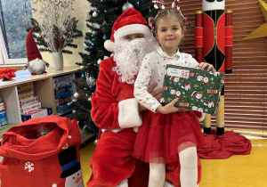 Dziewczynka pozuje do zdjęcia z Mikołaje.