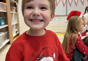 Uśmiechnięty chłopiec oczekuje na przybycie Mikołaja.