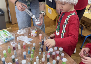 Chłopiec szuka odpowiedniego koloru brokatu.