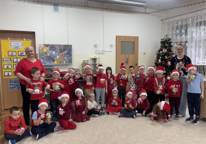 Dzieci pozują do wspólnego zdjęcia z panią, która prowadziła warsztaty.