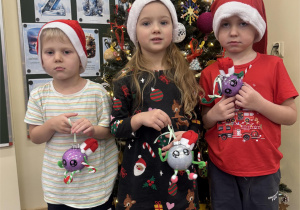 Dzieci prezentują bombki wykonane samodzielnie.