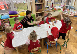 Pani pomaga dzieciom przy robieniu bombek.