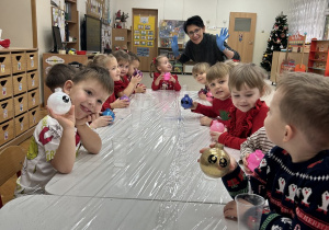 Dzieci prezentują brokatowe bombki.