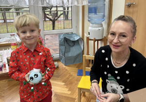 Chłopiec chwali się wytworem swojej pracy.