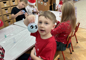 Chłopiec prezentuje gotową bombkę.