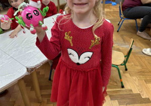Dziewczynka prezentuje wytwór swojej pracy.
