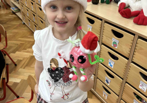 Dziewczynka prezentuje wytwór swojej pracy.