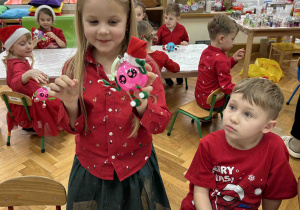 Dziewczynka prezentuje wytwór swojej pracy.