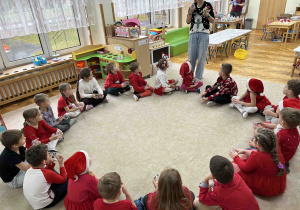 Dzieci słuchają pani jak wykonać bombki.