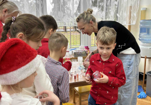 Chłopiec odebrał bombkę od pani.