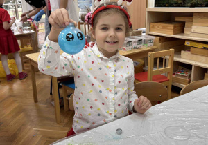 Dziewczynka pokazuje swoją bombkę.