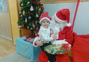 03. Chłopiec siedzi na kolanach Świętego Mikołaja.