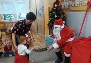 05. Dziewczynka odbiera prezent od Mikołaja.