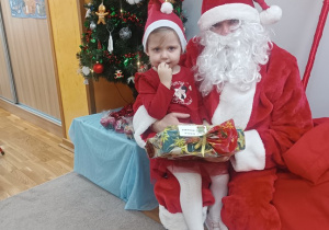 06. Dziewczynka siedzi na kolanach Świętego Mikołaja.