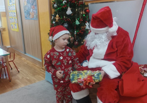 07. Chłopiec odbiera prezent od Mikołaja.
